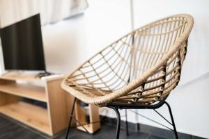a wicker chair sitting next to a desk with a television at Beach front Apartments 2-3-4 in (( Elaiónas ))