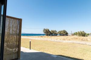 a wooden gate with a view of the beach at Beach front Apartments 2-3-4 in (( Elaiónas ))