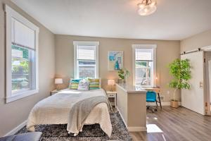 a bedroom with a bed and a desk and windows at Gig Harbor House with Private Beach and Views! in Gig Harbor