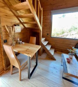 ein hölzernes Esszimmer mit einem Tisch und einem Fenster in der Unterkunft Mountain Eco Shelter 3 in Corujeira de Dentro