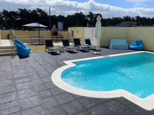 - une piscine sur une terrasse avec des chaises et un parasol dans l'établissement Moderne Villa in Aveiro Portugal, à Gafanha da Vagueira