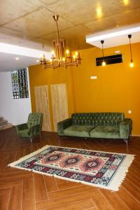 a living room with a green couch and a rug at Hotel mia Telavi in Tʼelavi