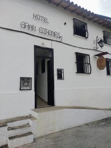 希龙Hotel Gran Girones的一栋白色建筑，上面有一扇门和一个标志