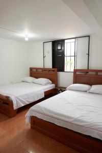 a bedroom with two beds and a window at Hotel Gran Girones in Girón