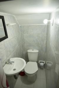 a white bathroom with a toilet and a sink at Hotel Gran Girones in Girón