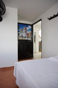 a bedroom with a white bed and a large window at Hotel Gran Girones in Girón