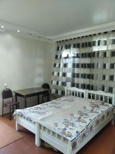 Roin Guest House في غريغوليتي: غرفة نوم بسرير وطاولة ونافذة