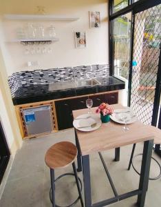 a kitchen with a wooden table with chairs and a sink at Palompon kalimba de luna Villa Inn in Leyte +35 photos