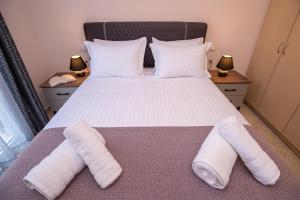 een slaapkamer met een bed met twee handdoeken erop bij Zoes Luxury Apartment Corfu in Ágios Rókkos