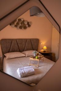 a bedroom with a bed with a table and a mirror at Zoes Luxury Apartment Corfu in Agios Rokkos