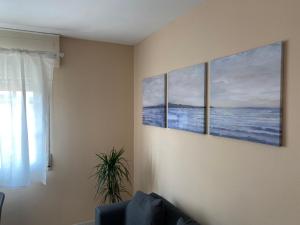 a living room with three paintings on the wall at Apartamento en Rias Baixas-Aguiño-Ribeira in Ribeira
