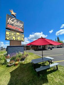 um sinal para um restaurante com uma mesa de piquenique em Holiday Motel em Sault Ste. Marie