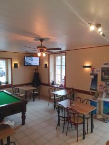 uma sala de jantar com mesas e uma mesa de bilhar em hotel de la gare em Verchamp