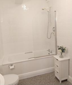 a bathroom with a white tub and a toilet at Town centre one bed apartment in Dungarvan
