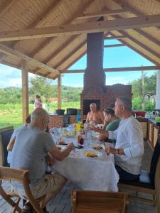 un grupo de hombres sentados en una mesa comiendo comida en Eco familia en Pojoga