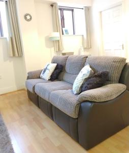 un sofá en una sala de estar con almohadas en Town centre one bed apartment en Dungarvan