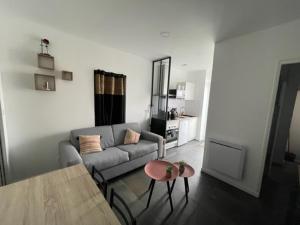 een woonkamer met een bank en een tafel bij - Le Nuage - Unique, espace Spa privatif et jardin avec plancha et salon privatif, stationnement public gratuit in Niort