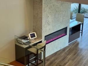 a living room with a desk and a fireplace at Amanzi Hotel, Ascend Hotel Collection in Ventura