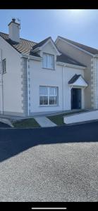 una casa blanca con una entrada delante de ella en Beach View Portnablagh Dunfanaghy, en Dunfanaghy