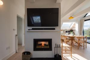 sala de estar con chimenea y TV encima. en Little Hayloft by Bloom Stays en Canterbury