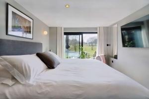 a bedroom with a large white bed and a window at Little Hayloft by Bloom Stays in Canterbury