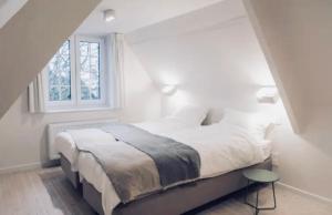 - une chambre blanche avec un lit et une fenêtre dans l'établissement Le Clos Margaux, à Chaudfontaine