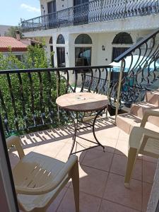 patio ze stołem i krzesłami na balkonie w obiekcie Castle By The Sea w mieście Artemida