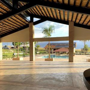 a large pavilion with a pool and a palm tree at Complexo Alpes do Cerrado in Sobradinho