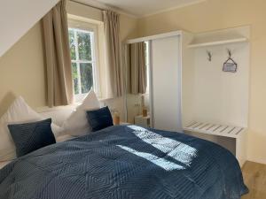 Schlafzimmer mit einem Bett mit blauer Decke in der Unterkunft Ferienhaus Svantovit - exklusives Ferienhaus mit Sauna, Whirlpool und Kamin in Putgarten