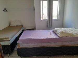 2 Betten in einem Zimmer mit Fenster in der Unterkunft Apartamento Temporada Praia do Morro in Guarapari