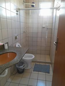 ein Bad mit einem WC, einem Waschbecken und einer Dusche in der Unterkunft Apartamento Temporada Praia do Morro in Guarapari