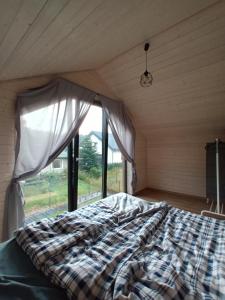Bett in einem Zimmer mit Fenster in der Unterkunft Zakątek na Ptasiej in Sasino
