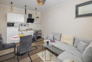 Una sala de estar con un sofá y una mesa y una cocina. en Apartment Citar, en Poreč