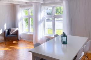 Habitación con mesa blanca, sillas y ventanas en Fedafjorden Apartments en Feda