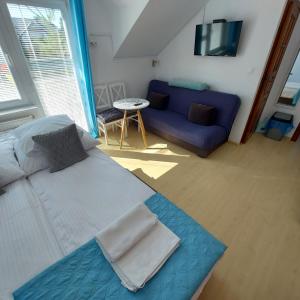 スバジェボにあるPokoje gościnne Jutrzenkaのベッドルーム(大型ベッド1台、青いソファ付)