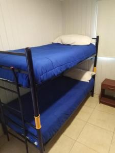 un par de literas con sábanas y almohadas azules en Camping Las Machas, en Bahía Inglesa