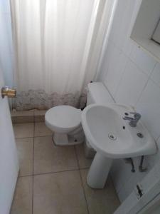 a bathroom with a white toilet and a sink at Camping Las Machas in Bahia Inglesa