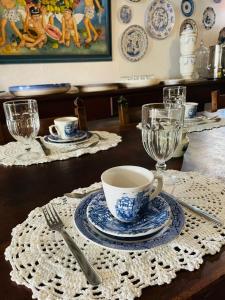 a table with a cup and a plate and a glass at Suítes Casa da Colônia in Paraty