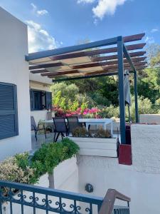 a patio with a pergola and a table with plants at Terpsichori villa and apartments in Kalamaki +52 photos