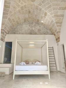 Cama blanca en habitación con techo de piedra en TS Residence en Gallipoli