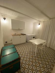 a kitchen with a white table and a table and chairs at fiori catene tra le torri in Conversano