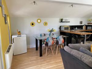 uma sala de estar com uma mesa e uma cozinha em Meadowside Lodge with Hot Tub em Truro