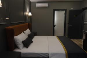 a bedroom with a large bed with black and white pillows at The Pearl Airport Hotel in Arnavutköy