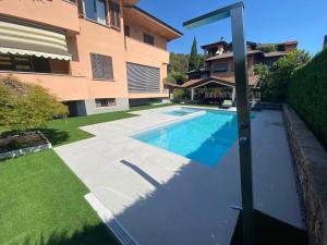 una piscina in un cortile accanto a una casa di B&B ARCOBALENO a Longone al Segrino