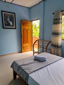 a bedroom with a bed with blue walls and a door at Nalluran illam - 2 bed room in Jaffna
