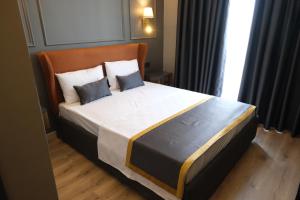 a bedroom with a large bed with two pillows at The Pearl Airport Hotel in Arnavutköy