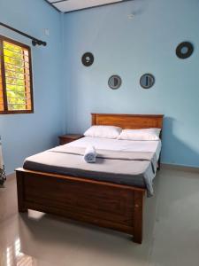 een slaapkamer met een bed in een blauwe kamer bij Nalluran illam - 2 bed room in Jaffna