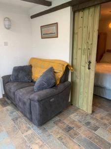 a brown couch with pillows sitting in a room at Molehill lodge in Swansea