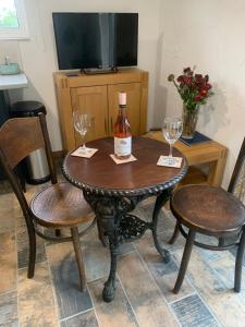 a table with a bottle of wine and two chairs at Molehill lodge in Swansea