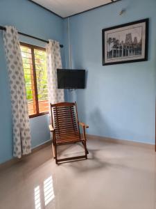 een schommelstoel in een kamer met een raam bij Nalluran illam - 2 bed room in Jaffna